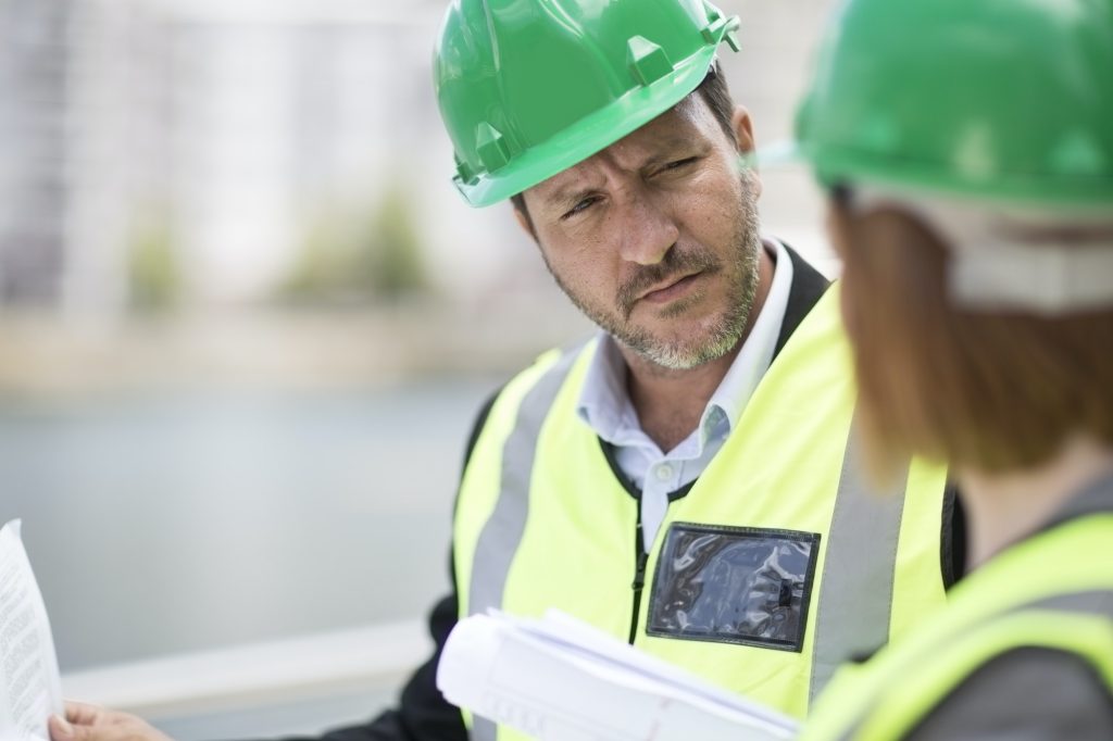 Manager and foreman discussing construction project on site