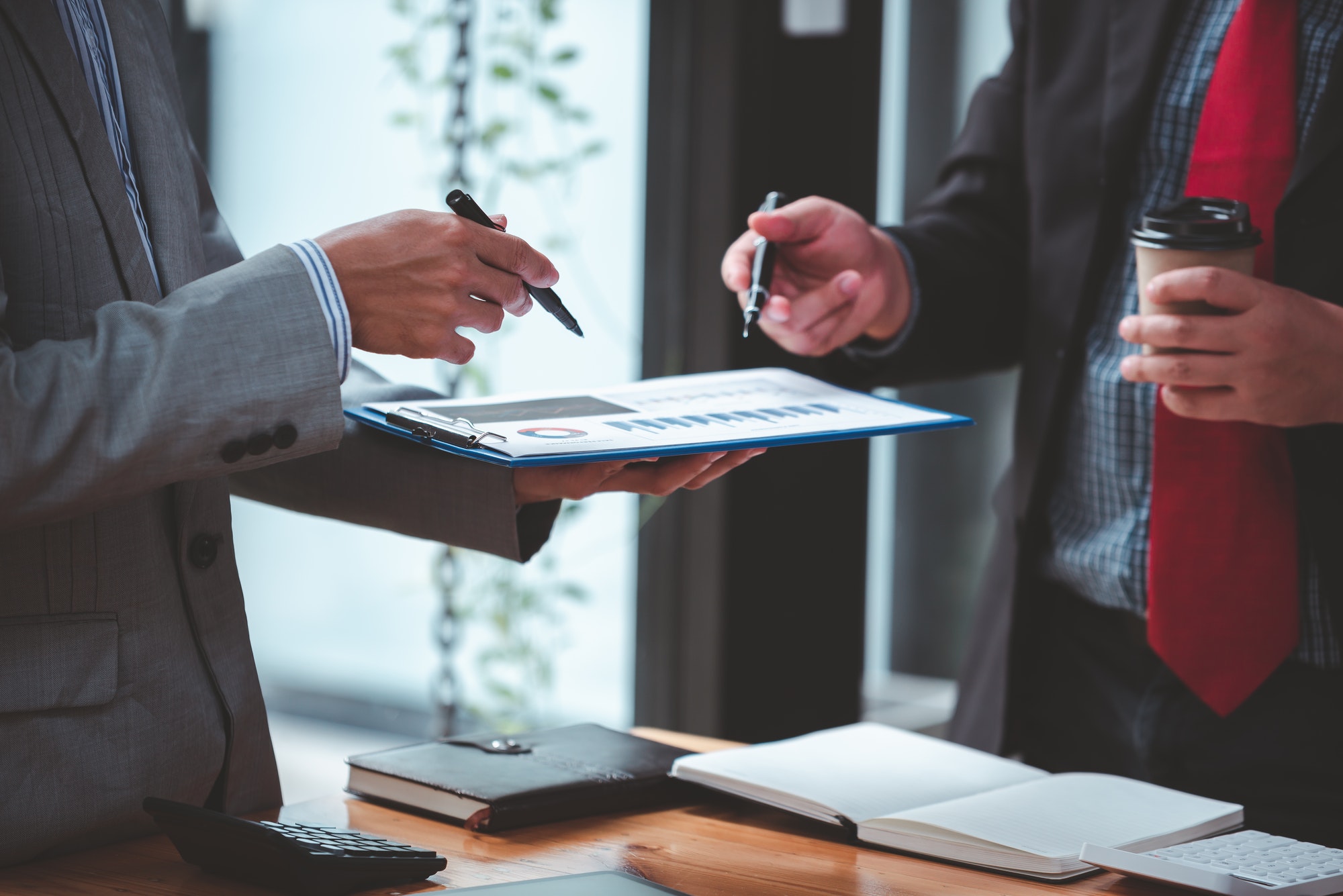 Businessmen meeting together to analyze project feasibility at office