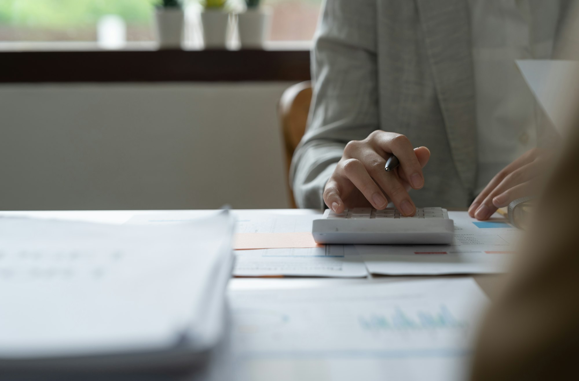 Close up woman using calculator financial documents, managing planning budget, accounting expenses