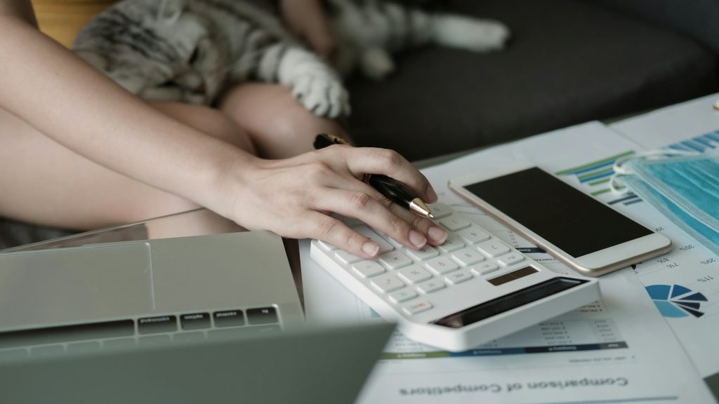 Female Hands Working On calculator for counting financial With her cat